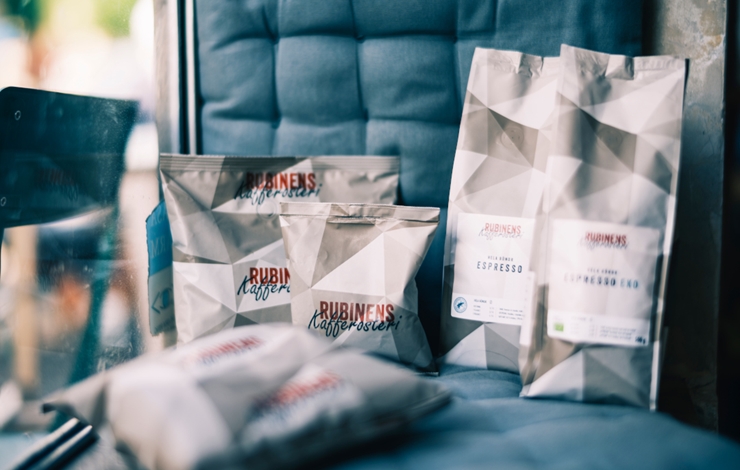 To poser kaffe plassert på en stol, den ene ved siden av den andre.