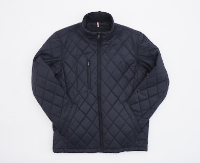 En mörkblp quiltad jacka tillverkad av tyg
