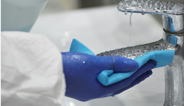 Engångshandskar med skyddsrock och trasa i handen