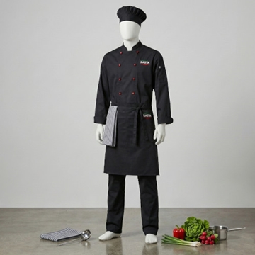 Exklusiva kockkläder med profilering för restaurang och storkök. Dockan bär en svart dubbelknäppt kockrock med röda kontrastknappar, matchande kockmössa och ett midjeförkläde med tydlig logotyp. En enhetlig klädsel som ger ett hygieniskt och proffsigt intryck i köket.
