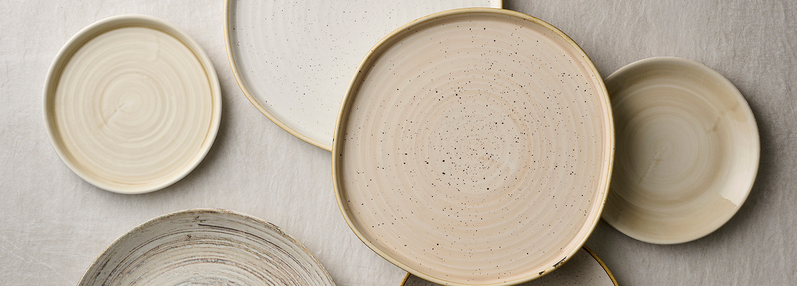 Runda tallrikar i olika nyanser va beige och natur
