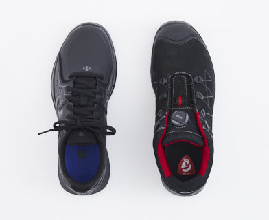 Två par svarta och röda arbetsskor på en vit bakgrund.